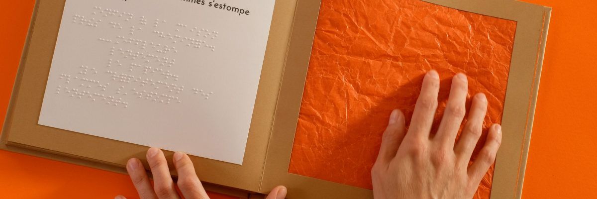Des mains sur un livre en Braille