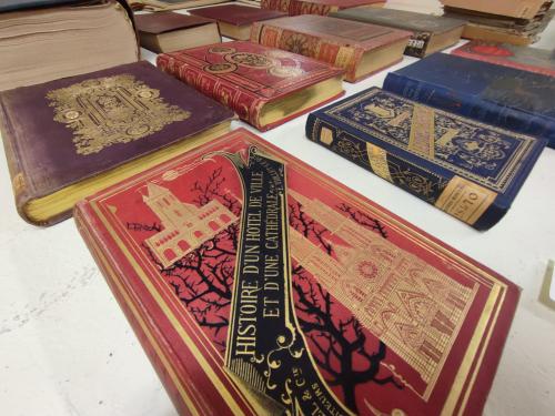 Livres posés à plat avec au premier plan une couverture rouge