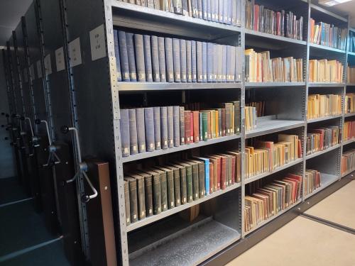 Etagère compactus avec de nombreux livres rangés sur les tablettes